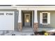 Front entry with gray siding, stone accents, and white door at 14 Baird Cv Ln, Angier, NC 27501