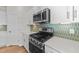 Modern kitchen with stainless steel appliances and green tile backsplash at 14 Baird Cv Ln, Angier, NC 27501