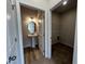 Bathroom with a pedestal sink and wood-look floor plus a view of the laundry room at 14 E American Marigold Dr # 65, Benson, NC 27504