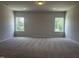 Large, carpeted bedroom with abundant natural light from two large windows at 14 E American Marigold Dr # 65, Benson, NC 27504