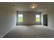 Spacious carpeted bedroom with neutral paint, two large windows and natural light at 14 E American Marigold Dr # 65, Benson, NC 27504