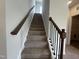 A well lit carpeted staircase features stained wood handrails and black metal balusters at 14 E American Marigold Dr # 65, Benson, NC 27504