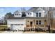 Two-story white house with stone accents, double garage, and a covered porch at 165 Tuskeegee Dr, Smithfield, NC 27577