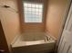 Bright bathroom with a large soaking tub and unique glass block window at 216 Parrish Farm Lane Ln, Benson, NC 27504