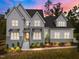 Stunning two-story home with gray and white siding, landscaping, and a metal roof at 2404 Toll Mill Ct, Raleigh, NC 27606