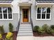 Modern front entry with gray brick, wood door, and a stone landing at 2404 Toll Mill Ct, Raleigh, NC 27606