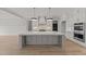 Island kitchen with white cabinets, gray island, and high-end appliances at 2404 Toll Mill Ct, Raleigh, NC 27606