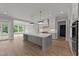 Spacious kitchen with eat-in island, white cabinets, and access to sunroom at 2404 Toll Mill Ct, Raleigh, NC 27606