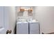 Functional laundry room with modern white washer and dryer, ample shelving, and Laundry Co sign at 8701 Wardle Ct, Wake Forest, NC 27587