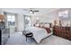 Bright main bedroom with a white bed, ceiling fan, multiple windows, and neutral decor with light-colored carpet at 8701 Wardle Ct, Wake Forest, NC 27587