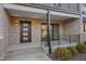 Townhouse entry with brick facade, dark door, and small patio at 1016 Manor Way, Durham, NC 27701