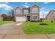 Two-story house with gray siding, white garage door, and landscaped lawn at 104 Davinhall Dr, Fuquay Varina, NC 27526