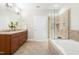 Bright bathroom with vanity, large mirrors, neutral colors, tub and separate glass shower at 10511 Sablewood Dr # 110, Raleigh, NC 27617