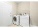 Bright laundry room with modern white washer and dryer, white door and wire rack shelving at 10511 Sablewood Dr # 110, Raleigh, NC 27617