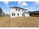 View of the white home's backyard with freshly seeded lawn at 107 Barn Door Dr, Lillington, NC 27546