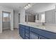 Bathroom featuring double sink vanity with blue cabinets and a shower at 107 Barn Door Dr, Lillington, NC 27546
