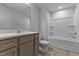 Bathroom features a modern vanity with drawers, stone countertop, tile floor, and tub with shower at 107 Barn Door Dr, Lillington, NC 27546