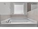Soaking tub with tile backsplash, window and chrome fixtures at 107 Barn Door Dr, Lillington, NC 27546