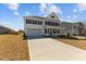 Beautiful two-story home with a covered front porch, attached garage, and a spacious front yard at 107 Barn Door Dr, Lillington, NC 27546