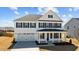 Two-story white home with black shutters, a covered front porch, and a two-car garage at 107 Barn Door Dr, Lillington, NC 27546