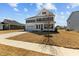 Two-story white home with black shutters, a covered front porch, a tree in the front yard, and a two-car garage at 107 Barn Door Dr, Lillington, NC 27546