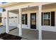 Inviting covered front porch with white columns, number 101, black shutters, and view of the garage at 107 Barn Door Dr, Lillington, NC 27546