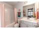 Stylish bathroom with tub shower combo, gray vanity, and peach curtain at 117 Sunburst Ct, Fuquay Varina, NC 27526