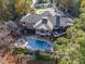 Stunning aerial view of the property with a pool, patios, decks and lush greenery at 12044 Iredell, Chapel Hill, NC 27517