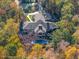 Overhead view of a luxurious property nestled among colorful trees, featuring a large home and sparkling pool at 12044 Iredell, Chapel Hill, NC 27517