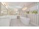 Luxurious bathroom featuring a soaking tub, double vanity, and elegant lighting at 12044 Iredell, Chapel Hill, NC 27517