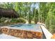 A relaxing stone hot tub and lush landscaping create a private and tranquil backyard retreat at 12044 Iredell, Chapel Hill, NC 27517