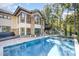 An inviting in-ground pool, stone accents, and large windows enhance the exterior of this magnificent home at 12044 Iredell, Chapel Hill, NC 27517