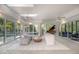 Bright sunroom with floor-to-ceiling windows, skylights, and a grand piano, perfect for relaxation at 12044 Iredell, Chapel Hill, NC 27517