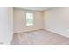Simple carpeted bedroom with large window, neutral walls, and ample space at 121 Barn Door Dr, Lillington, NC 27546