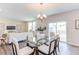 Open concept dining room with glass table and six chairs, natural light at 121 Barn Door Dr, Lillington, NC 27546