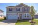 Two-story house with gray siding, white garage door, and red front door at 121 Barn Door Dr, Lillington, NC 27546