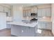 Modern kitchen with gray cabinets, white countertop island, and herringbone backsplash at 121 Barn Door Dr, Lillington, NC 27546