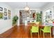 Bright dining room features hardwood floors, a wood table with green chairs, and views into the kitchen at 1211 E Martin St, Raleigh, NC 27610