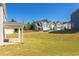 Large backyard with grassy area and homes in the background at 128 Baird Cv Ln, Angier, NC 27501