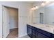 Double vanity bathroom with dark blue cabinets and walk-in closet at 133 Barn Door Dr, Lillington, NC 27546