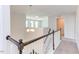 Upstairs hallway with dark wood railing and a chandelier at 141 Little Br Dr, Lillington, NC 27546