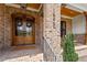Elegant double wooden doors with glass panels and brick facade at 1505 Montvale Grant Way, Cary, NC 27519