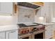 Modern range with red knobs and custom tile backsplash is the centerpiece of this kitchen at 1505 Montvale Grant Way, Cary, NC 27519