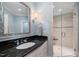 Bathroom with dark granite countertop, glass shower, and stylish mirror at 15508 Possum Track Rd, Raleigh, NC 27614