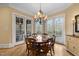 Bright breakfast nook features a round table, chandelier, and access to a deck at 15508 Possum Track Rd, Raleigh, NC 27614