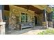 Inviting front porch with stone columns and a bench at 15508 Possum Track Rd, Raleigh, NC 27614