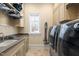 Laundry room with washer, dryer, sink, and ample cabinet space at 15508 Possum Track Rd, Raleigh, NC 27614