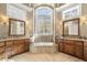 Luxurious bathroom with double vanities, soaking tub, and large window at 15508 Possum Track Rd, Raleigh, NC 27614