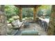 Relaxing stone patio with pergola, seating, and chandelier at 15508 Possum Track Rd, Raleigh, NC 27614