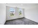 Bright bedroom featuring gray carpet, white walls and two windows letting in natural light at 1705 Clydner Dr, Cary, NC 27523
